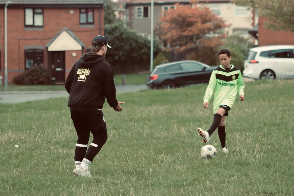 Box to Box Academy coach working with a young footballer